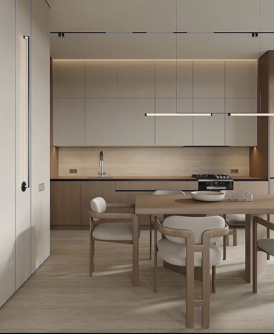 Flat cabinet fronts, darker tall units and a pale backsplash form a restrained kitchen palette.