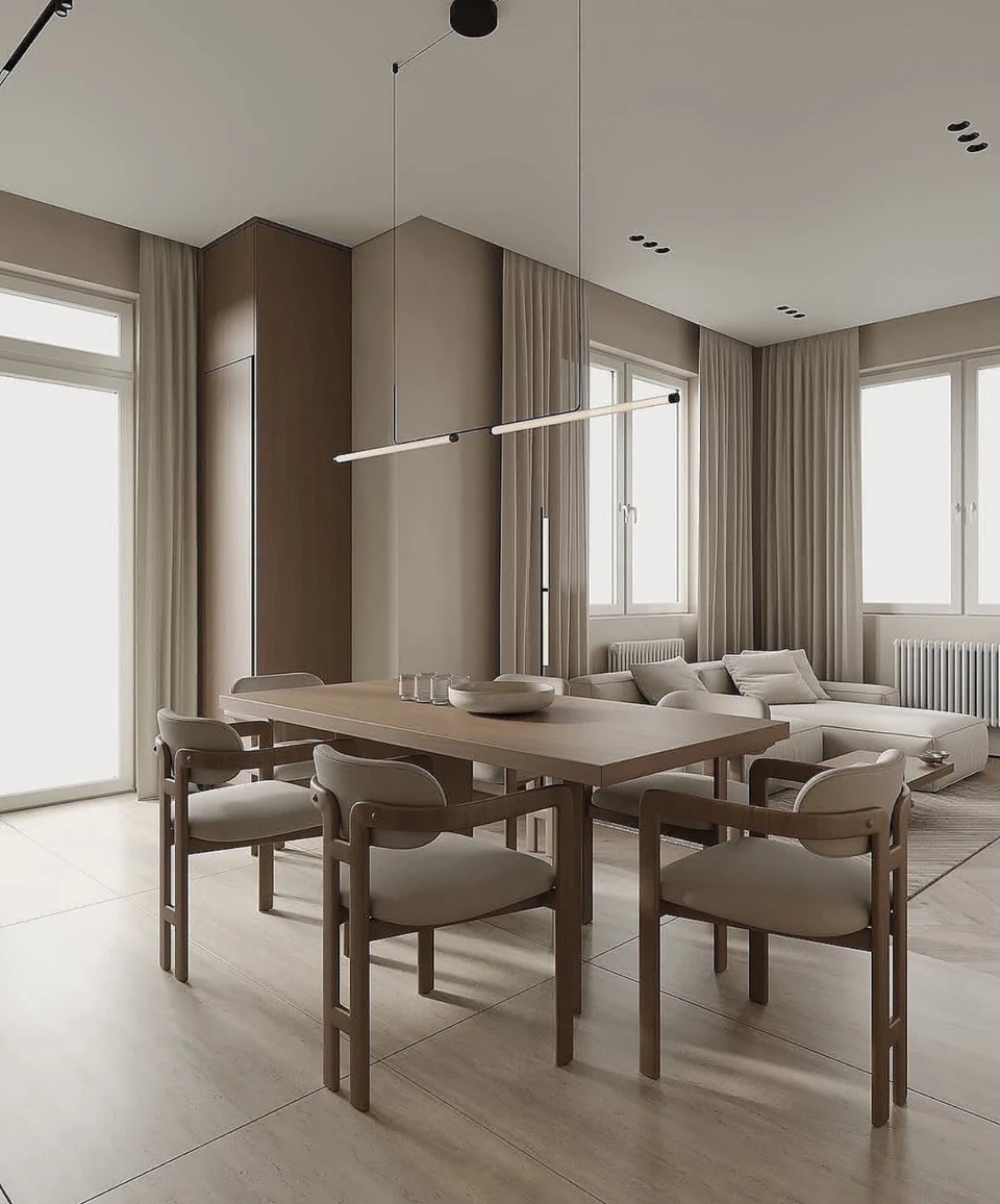 Window light, layered curtains and wood-toned dining furniture soften the cabinet geometry.