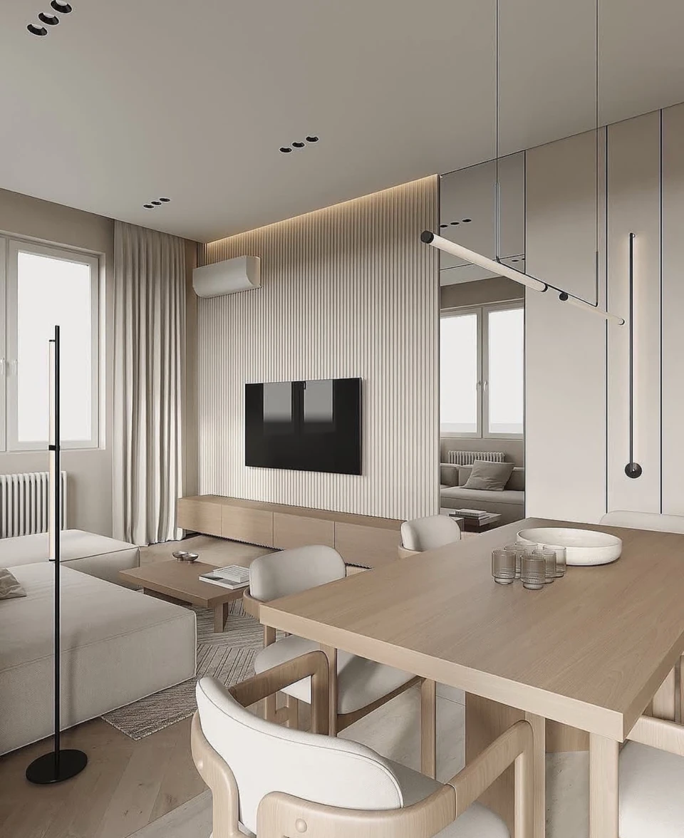 A simple wall-mounted screen and light wall finishes maintain the restrained character of the adjoining dining area.