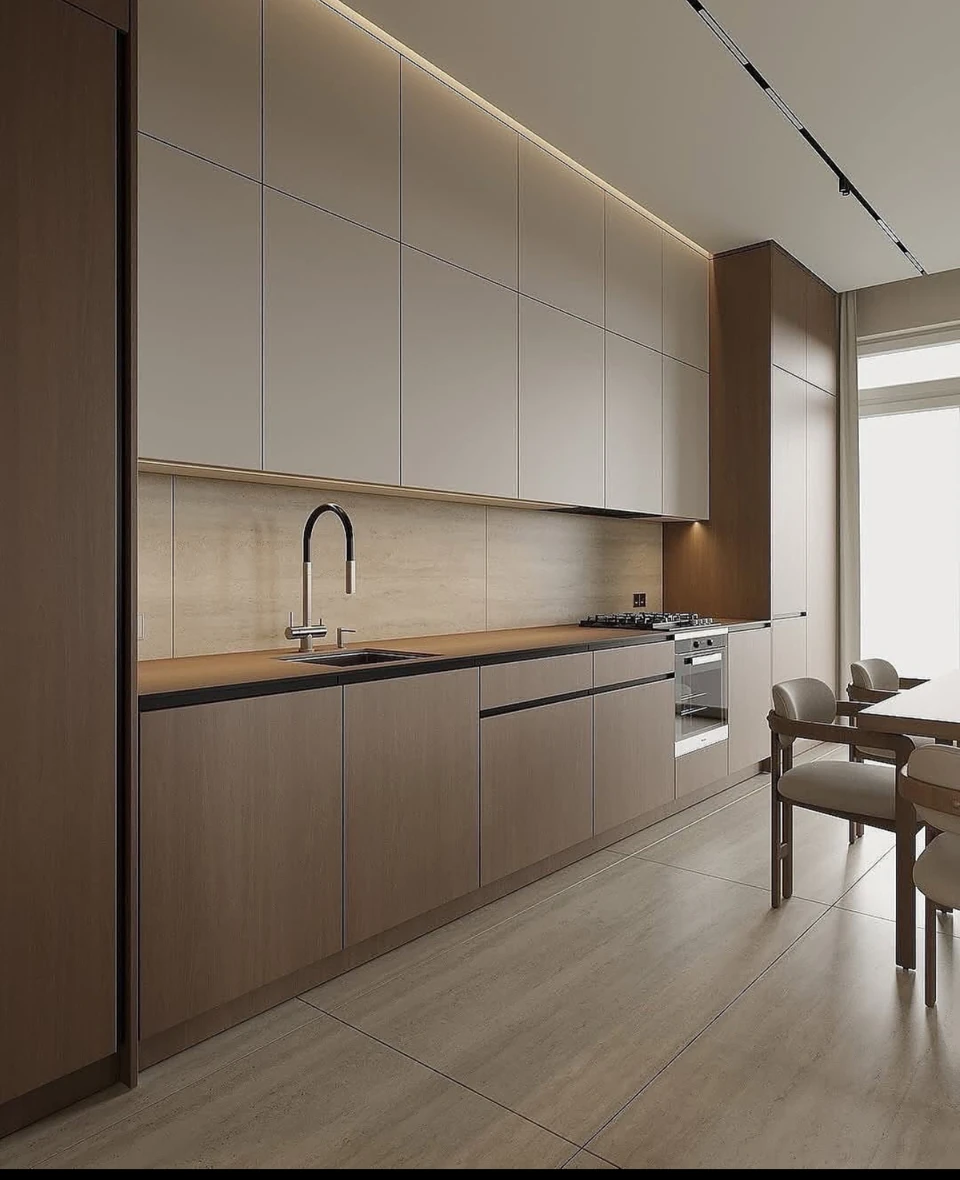 A close view of flat-front cabinetry, the sink, the pale backsplash and warm under-cabinet lighting.