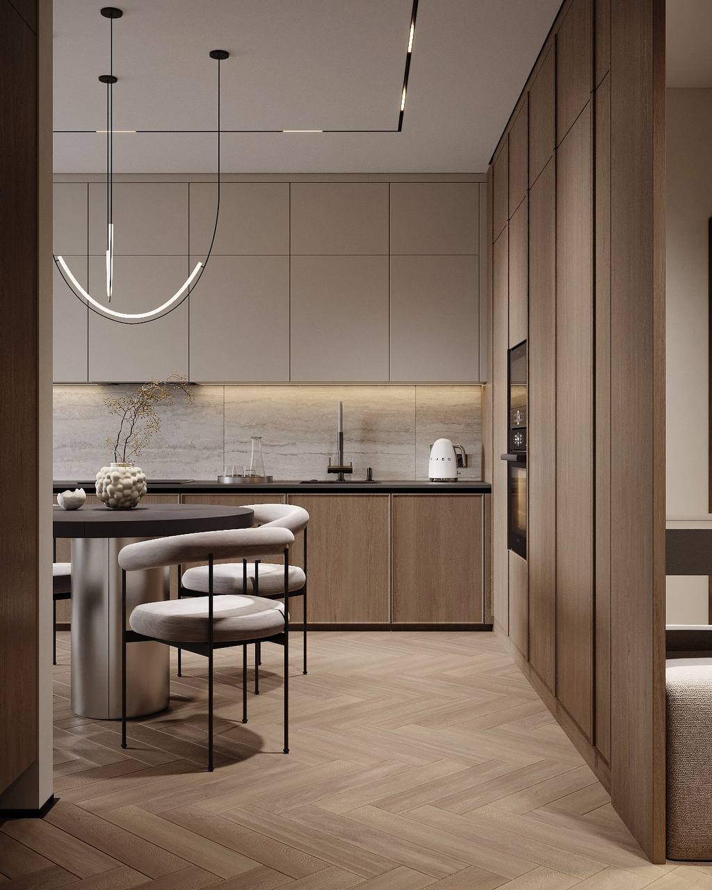 The kitchen and dining area framed by full-height cabinetry and a continuous herringbone floor.
